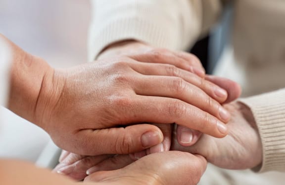 Stack of four hands, two younger, two older